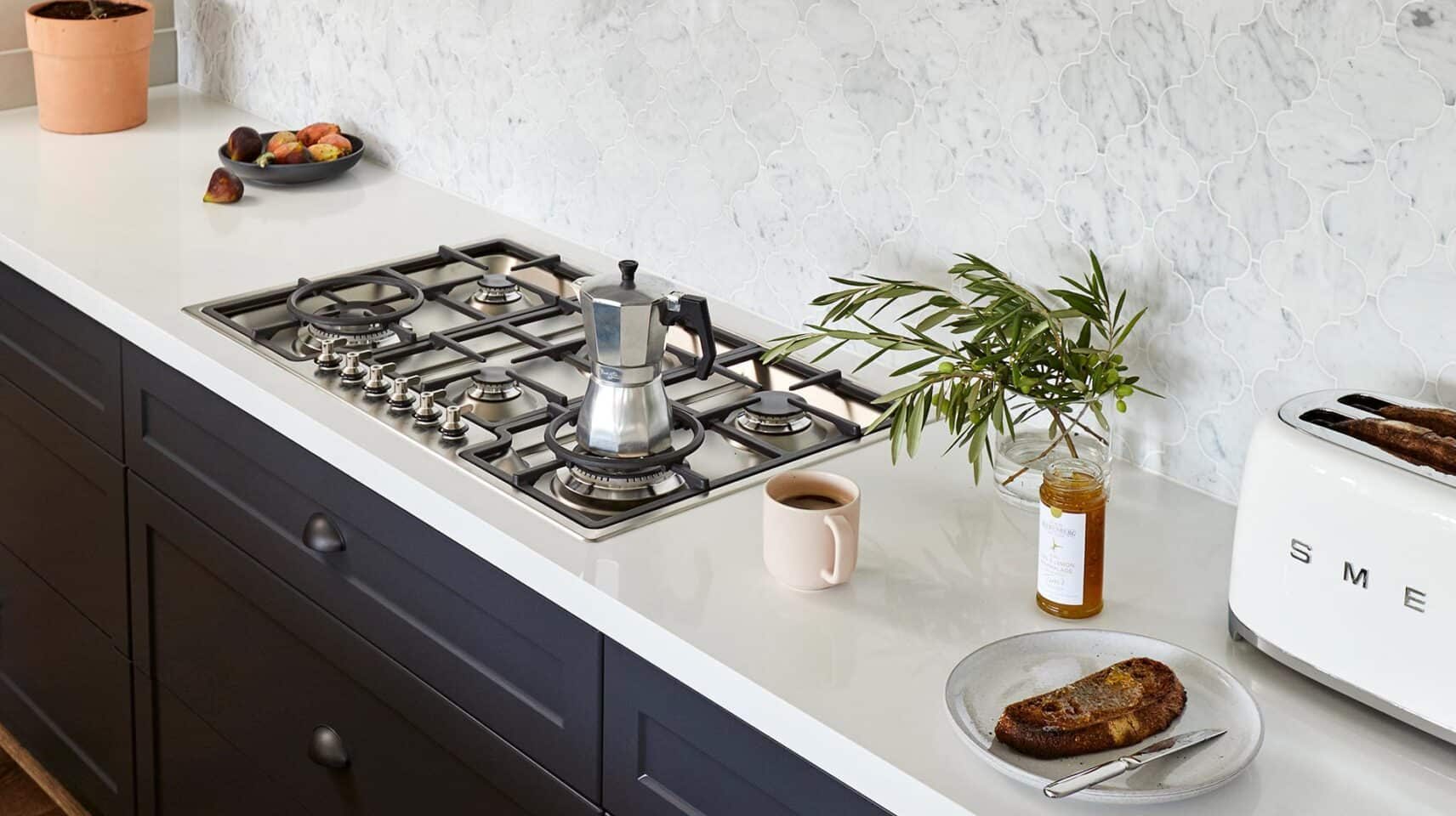 dark blue kitchen with white work surfaces