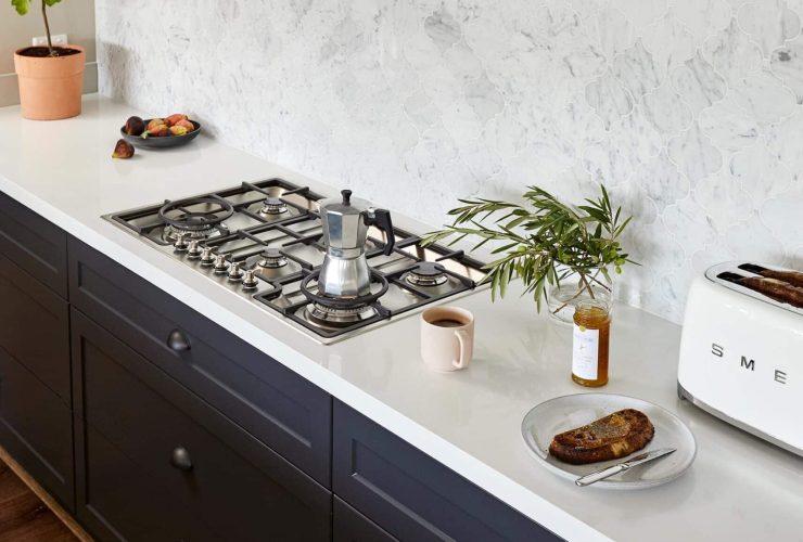 dark blue kitchen with white work surfaces