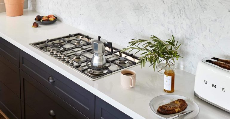 dark blue kitchen with white work surfaces